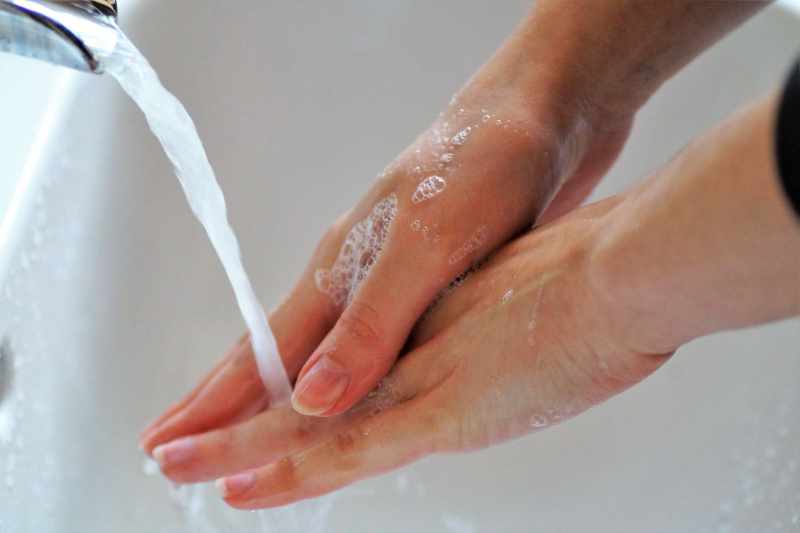 Person washing their hands under running water